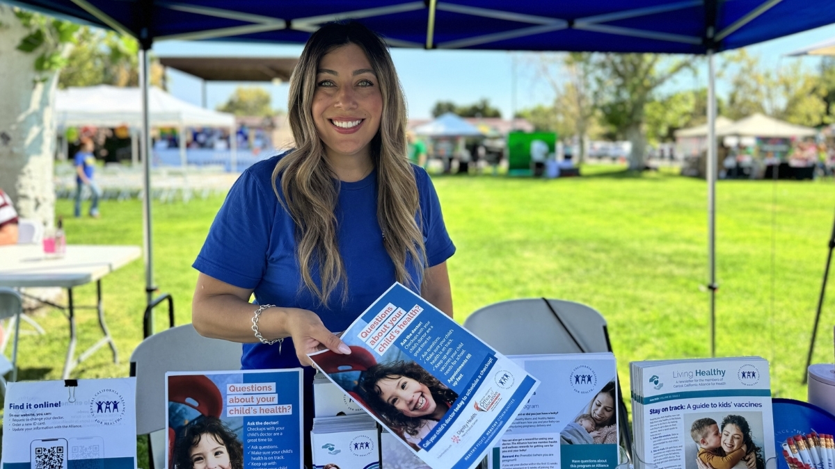 یکی از کارکنان زن اتحاد، بروشوری در دست دارد و لبخند می‌زند.