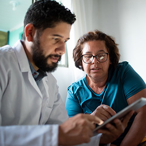 A provider and a patient reviewing a tablet for medi-cal changes