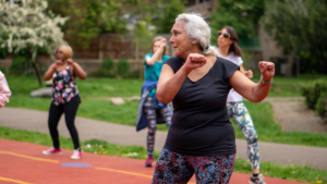 Woman exercises outside in group fitness class.