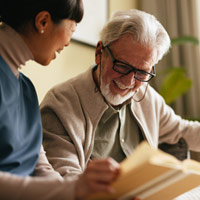 Older man and woman reading a book