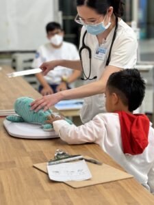Nurse showing teaching young boy with whale stuffed animal