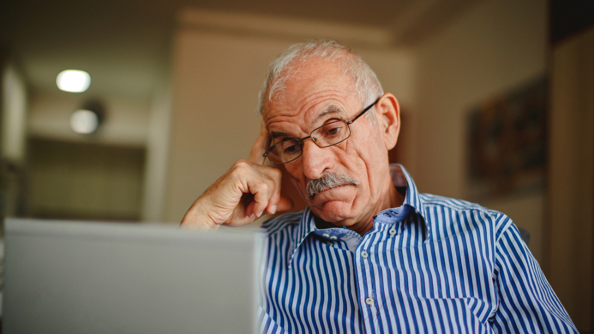 Tus txiv neej laus saib ntawm lub laptop