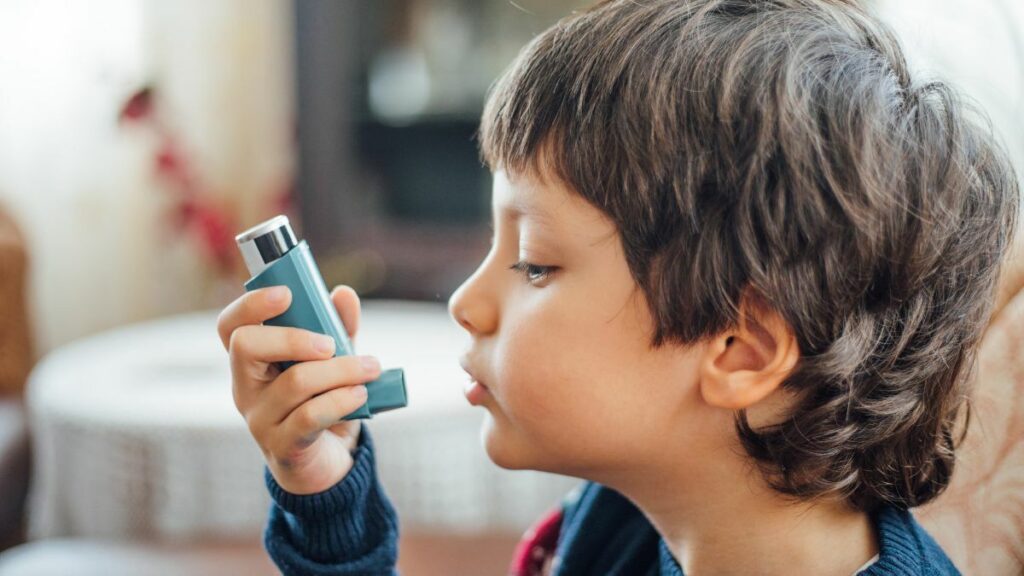 young boy using an inhaler for asthma