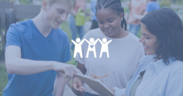 Ib tug txiv neej thiab ob tug poj niam saib xyuas cov ntaub ntawv qhia kev tshaj tawm hauv daim ntawv clipboard ntawm qhov kev tshwm sim sab nraum zoov.