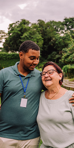 Двое обнимаются, стоя рядом, у одного из них на ремешке бейджа.