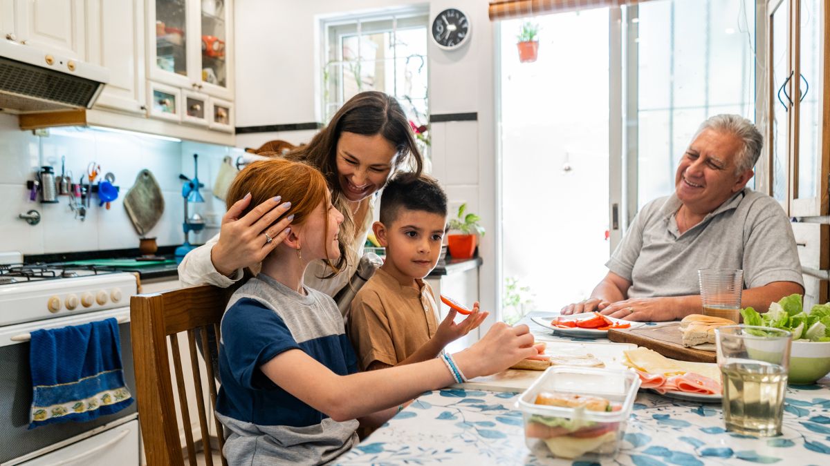 ਬਹੁ-ਪੀੜ੍ਹੀ ਪਰਿਵਾਰ ਰਸੋਈ ਦੇ ਮੇਜ਼ 'ਤੇ ਬੈਠਾ ਹੈ